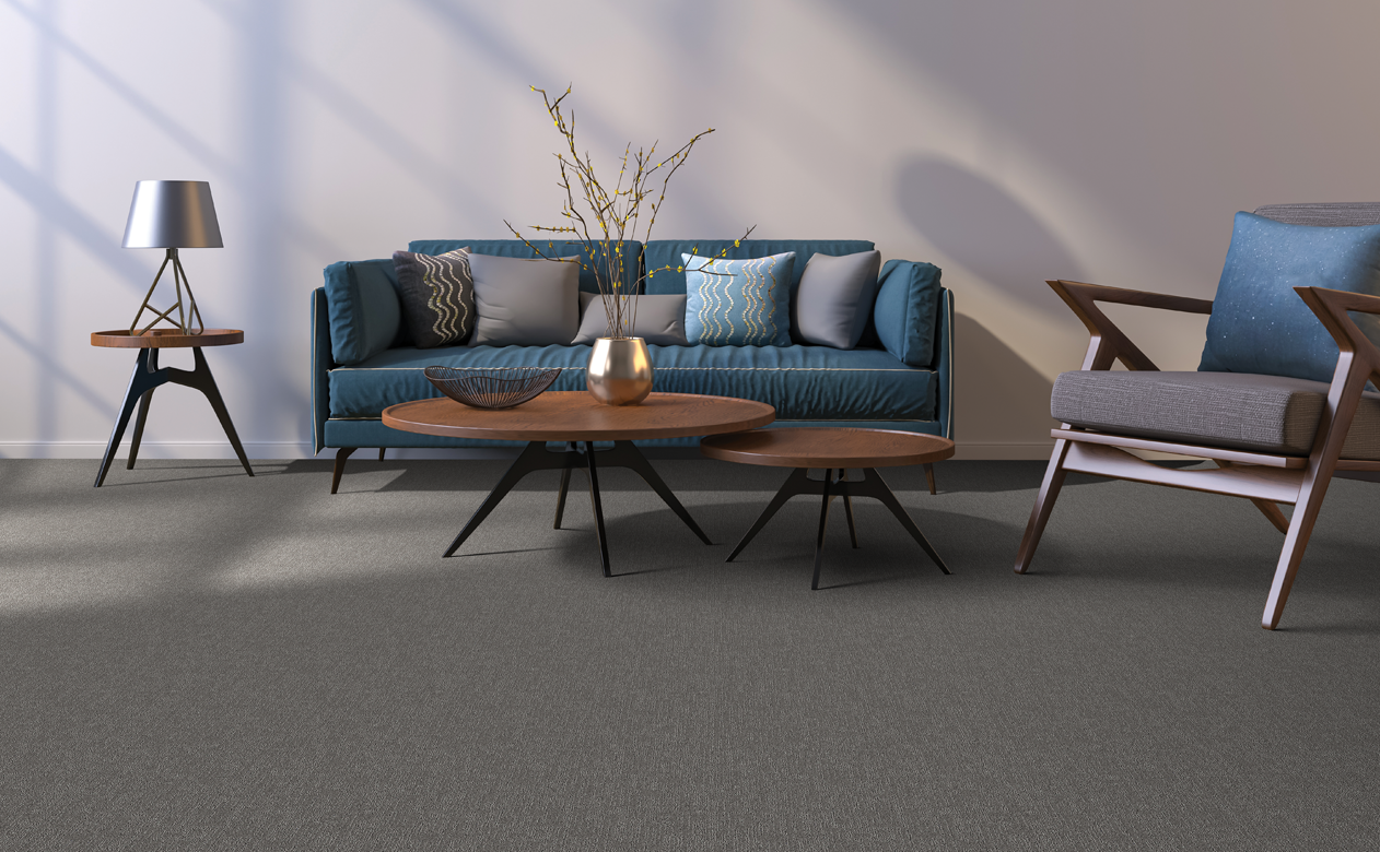 Grey carpet in living room with navy couch and wooden coffee table